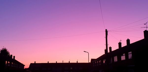 Low angle view of silhouette buildings against sky during sunset