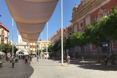 People on street amidst buildings in city