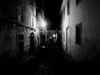 Illuminated street amidst buildings at night