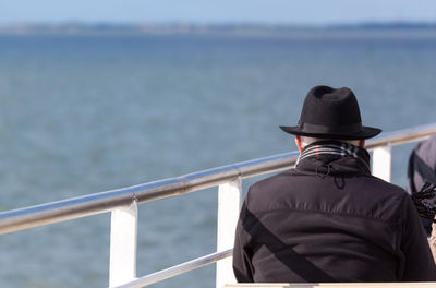 Rear view of man in sea against sky