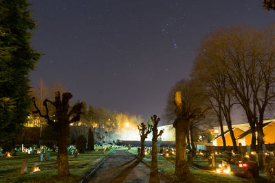 Illuminated grave stones against sky at night