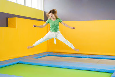 Full length of woman jumping on trampoline