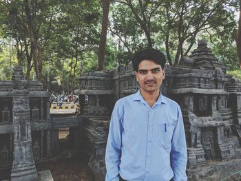 Portrait of man standing by built structure