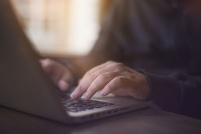Midsection of man using laptop on table