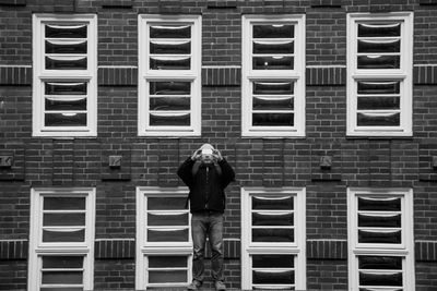 Full length of man photographing against building