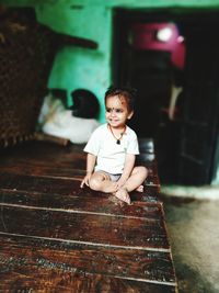 Portrait of a smiling girl sitting on floor at home