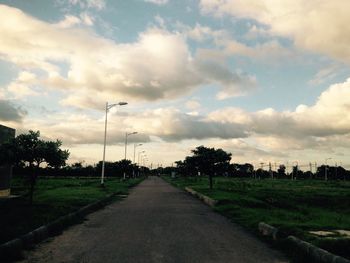 Empty road against cloudy sky