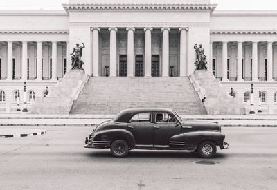 Vintage car on street against building in city