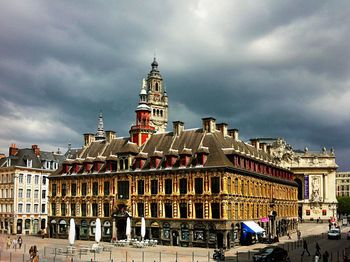 Buildings against cloudy sky