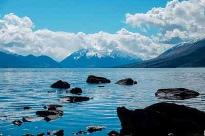 Scenic view of sea and mountains against sky