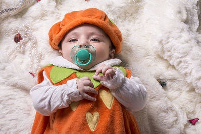 Portrait of cute baby girl lying on bed 