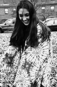 Playful young woman with shawl at park