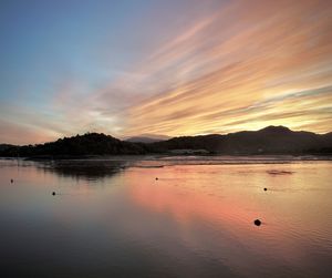 Scenic view of lake against sky at sunset