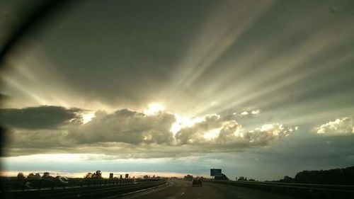 Road passing through landscape against cloudy sky