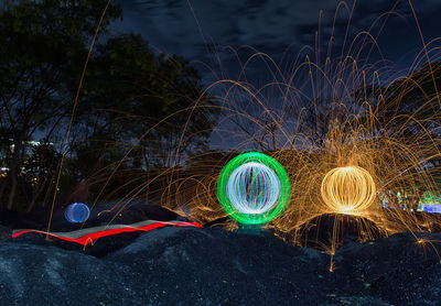 Light trails on field against sky at night