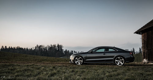 Car on field against clear sky