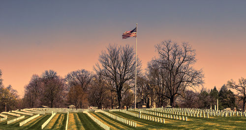 American flag at crown hill cemetery against sky during sunset