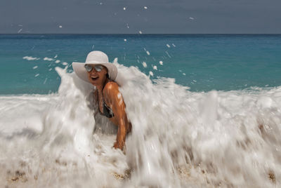 Young man in sea against sky