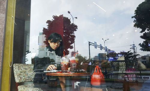 Woman looking through city window