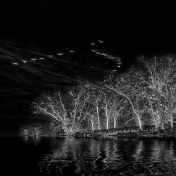 Scenic view of illuminated lake against sky at night