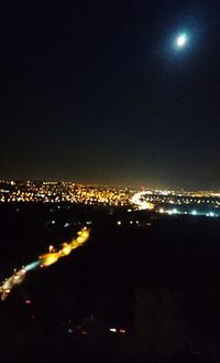 Illuminated cityscape against sky at night