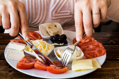 Midsection of woman holding food in plate