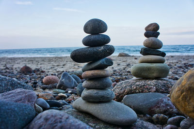 Stack of stones on beach against sky