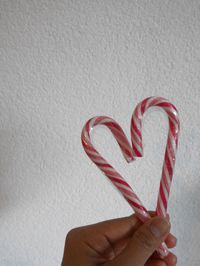 Close-up of hand holding heart shape against white background