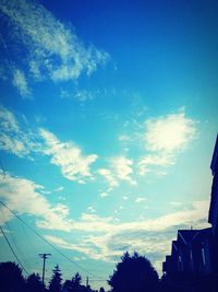 Low angle view of power lines against blue sky