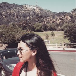 Beautiful young woman on road by trees