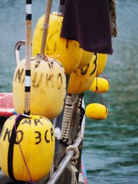 Close-up of yellow decoration hanging on metal by sea