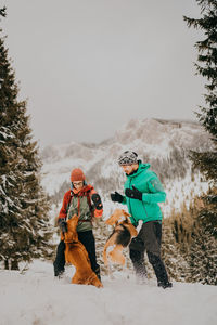 Couple in love and dogs playing in the snow