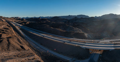 High angle view of road by mountains against clear sky