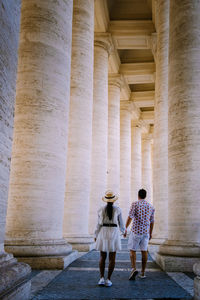 Full length rear view of woman walking in historical building