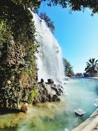 Scenic view of waterfall against sky