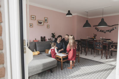 Two girls playing with grandparents in living room at home