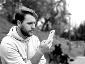 Young man using smart phone outdoors