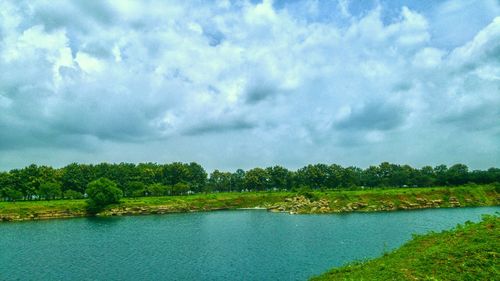 Scenic view of lake against cloudy sky