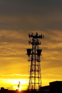 Low angle view of silhouette communications tower against sky during sunset