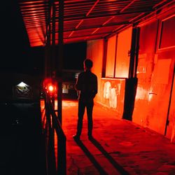 Rear view of silhouette man walking in illuminated building