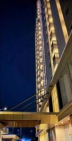 Low angle view of illuminated modern building against sky at night