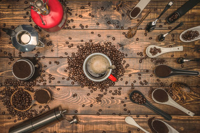 Directly above shot of coffee cup amidst spoons on table