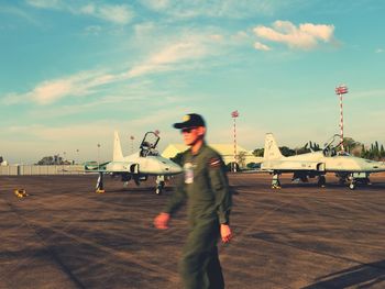 Man at airport runway against sky