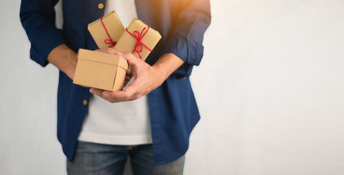 Midsection of man holding camera in box