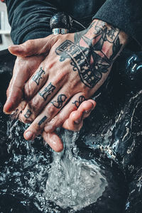 Close-up of hands holding glass of water