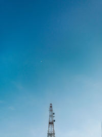 Low angle view of communications tower against clear blue sky