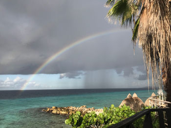 Scenic view of rainbow over sea against sky