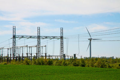 Electricity pylon on field against sky