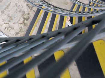 High angle view of yellow railing by fence