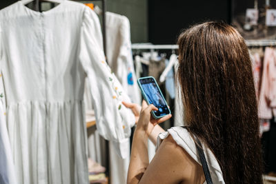 Ecommerce and sell online. woman taking picture of clothes in the shop. second hand, selling used